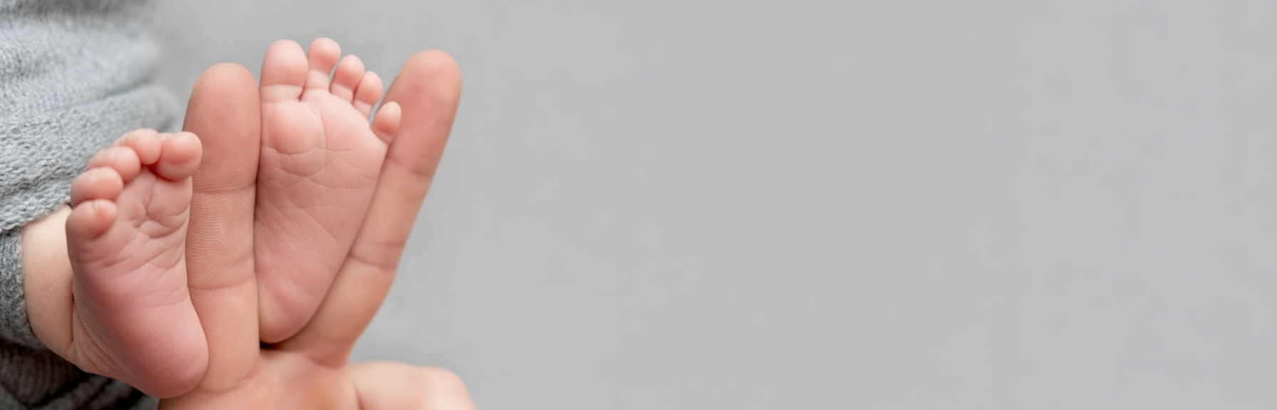 Baby feet cradled in loving hands